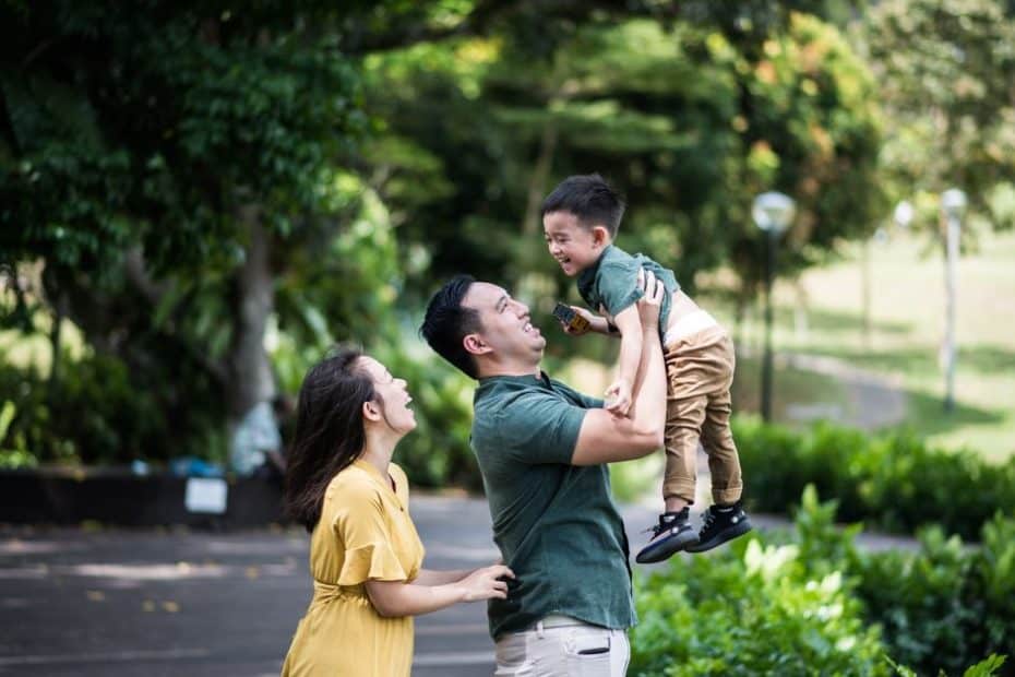 Family bonding moment in Singapore park representing insurance savings plans protection