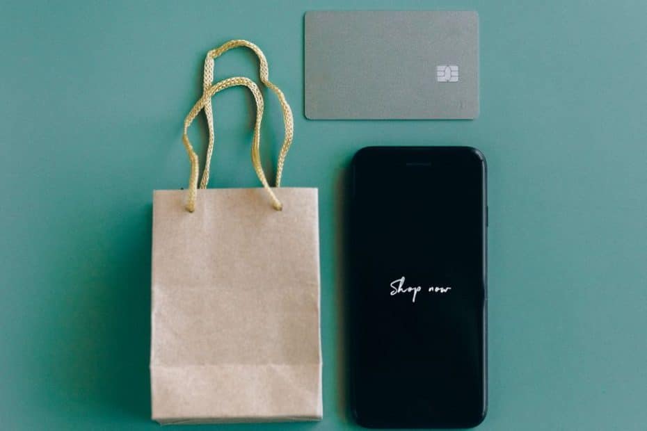 Buy now pay later Singapore: smartphone, credit card and shopping bags on a table