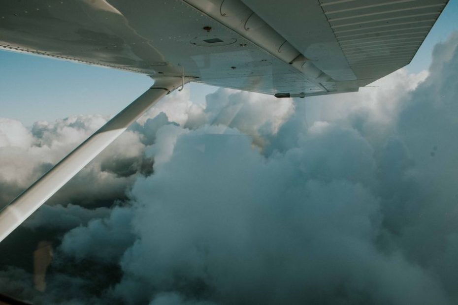Credit card miles Singapore 2026: airplane wing over clouds from a plane window