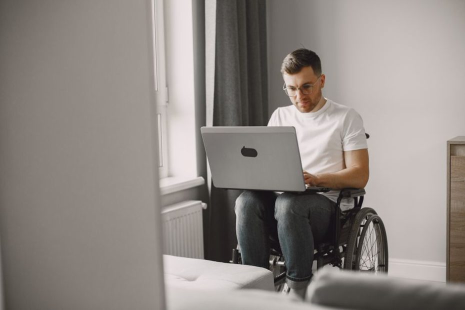 Disability income insurance Singapore: man in wheelchair working on a laptop at home